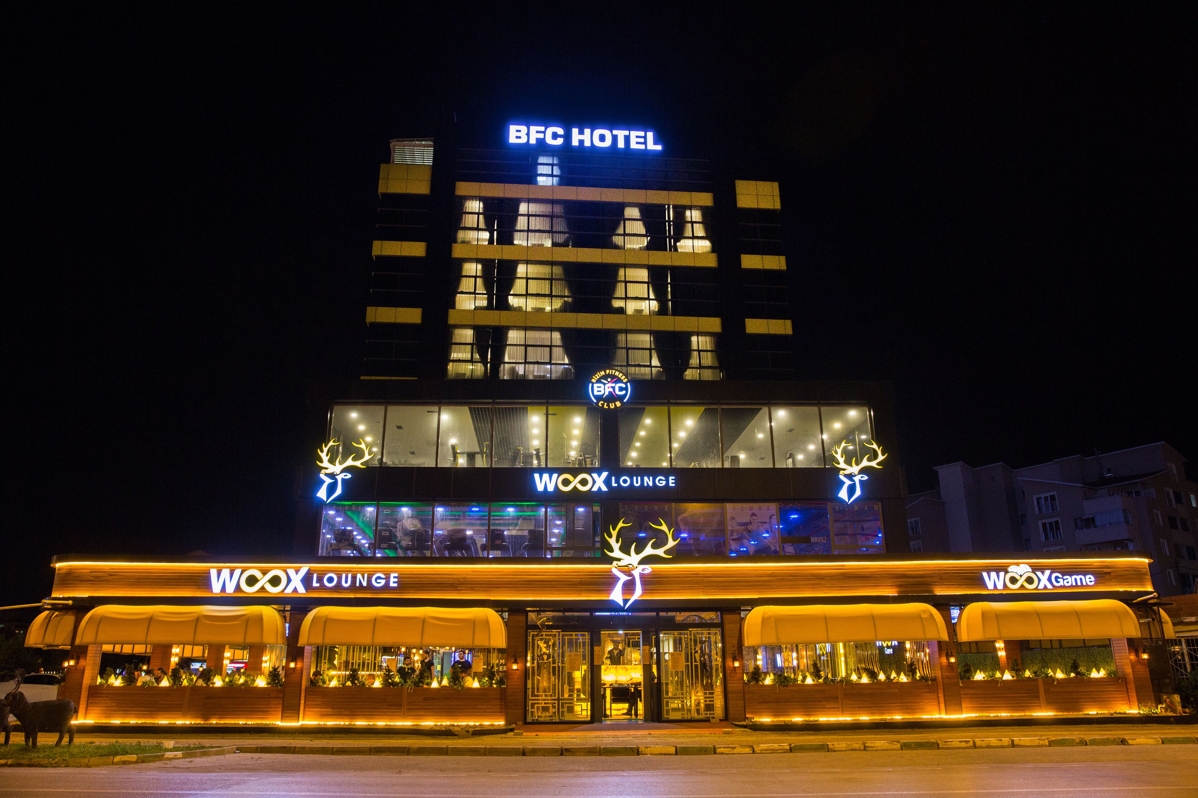 A hotel with a BFC Hotel sign, a Woox Lounge, and a Woox Game area.