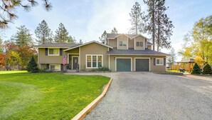 Ein zweigeschossiges Haus mit Auffahrt, Garage und gepflegtem Rasen.
