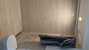 Cabezal de ducha tipo lluvia, secador de pelo, toallas y papel higiénico