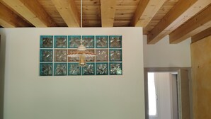 A room with a wooden ceiling and a wall-mounted light fixture. - House in the woods. (Dolo)