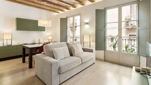 A modern living room with a sofa, dining table, and chairs. There are large windows with a view of the outside. - Modern and comfortable apartment in the heart of the city (Barcelona)