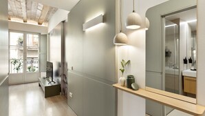 A modern bathroom with a large mirror, a wooden vanity, and pendant lights. - Modern and comfortable apartment in the heart of the city (Barcelona)