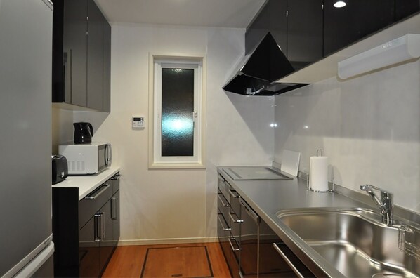 Features a sleek cabinetry, stainless steel sink, and compact layout with a window.