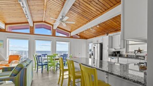 A modern kitchen with white cabinets, a granite countertop, and a view of the city. - Pool - Ocean Front - Dogs OK! (Emerald Isle)