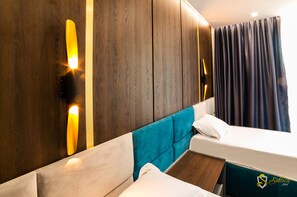 A hotel room with a wooden wall, a teal headboard, and a bed with white bedding. - Hotel Saftica (Balotesti)