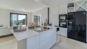 Cocina moderna con una isla central, electrodomésticos integrados y vistas al exterior.