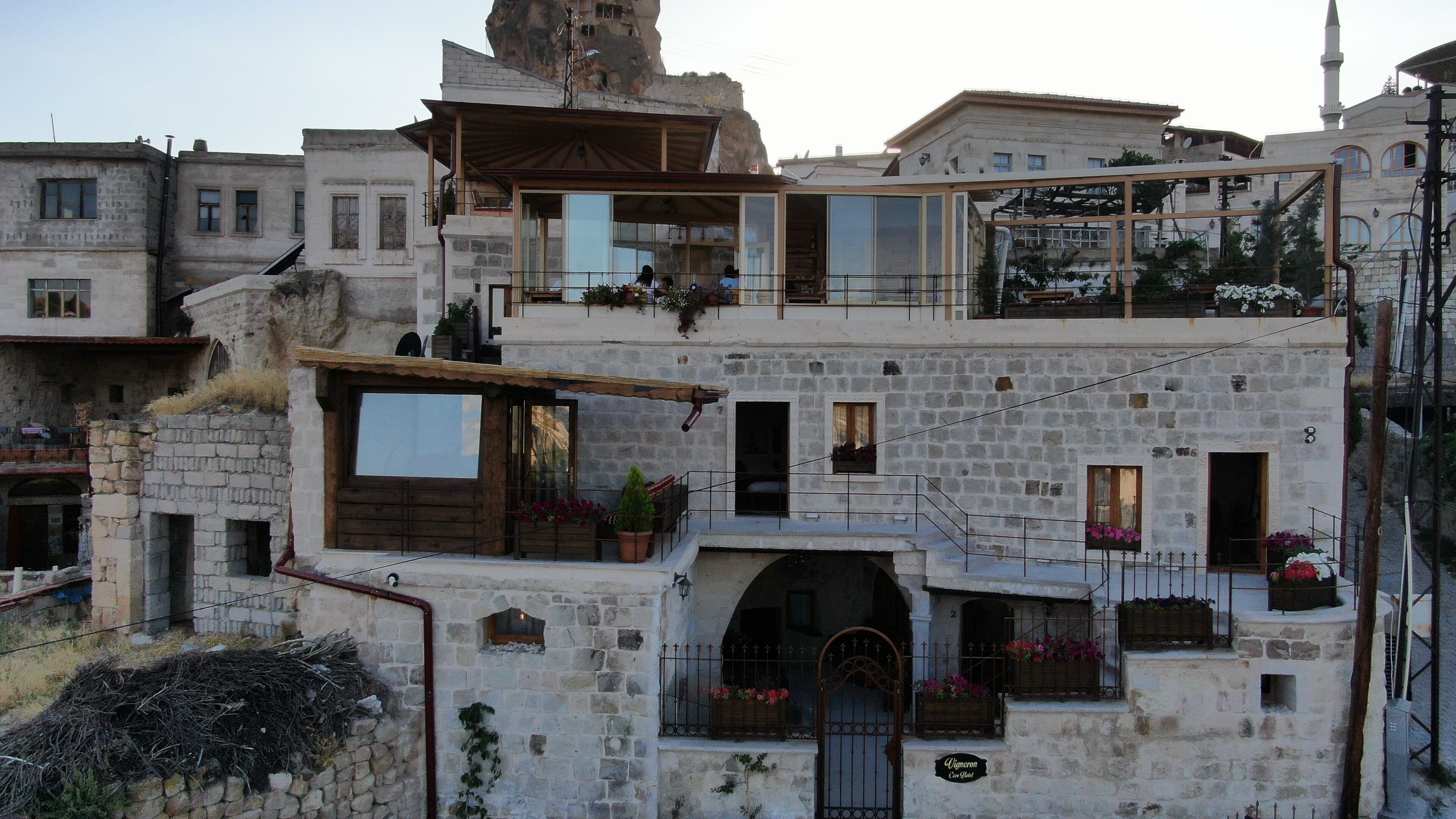 Un edificio de varios pisos de piedra, con balcones, ventanas y una entrada central.