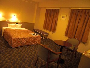 Relax in this inviting room with a comfortable bed, a small table, and two chairs.