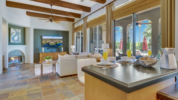 A spacious living area with a fireplace, a large television, and a dining area with a bar. - FALL GETAWAYS 25% OFF - Private and Serene - Room for the whole Family (La Quinta)