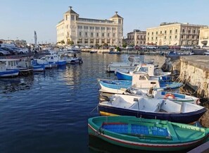 A marina with several small boats docked near a large building with a dome and columns. - 1 bedroom private vacation home in Floridia (Floridia)