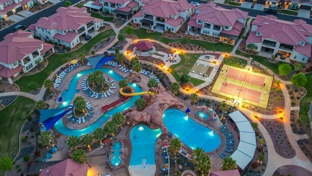 A resort with multiple swimming pools, a water slide, tennis courts, and lounge areas.