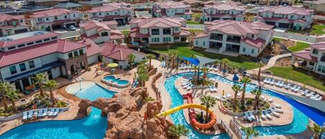 Um bairro residencial com várias casas, uma piscina central e um toboágua.