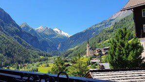 Un village de montagne avec une église, des maisons et une vue dégagée sur les montagnes environnantes.