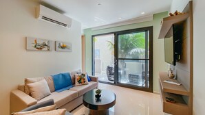 A modern living room with a sofa, coffee table, and TV. - Waykiri Unit C-08 Luxurious New Apartment, Noord (Noord)