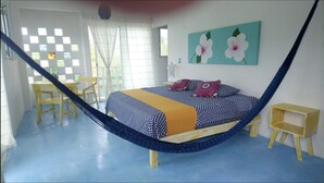 A room with a bed, a hammock, a desk, and a chair. - Casa Vainilla (Isla Holbox)