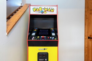 A Pac-Man arcade machine with a yellow and black color scheme, a joystick, buttons, and a coin slot.