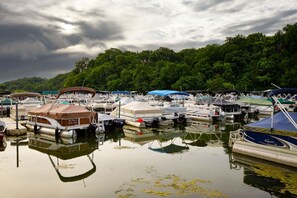 A marina with multiple boats docked, surrounded by lush greenery and a cloudy sky. - Spacious 5BR Retreat with Hot Tub, Fireplace & Game Room | Galena Territory (Galena)