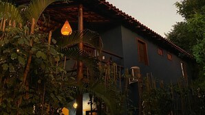 Una casa con techo de tejas, rodeada de abundante vegetación.