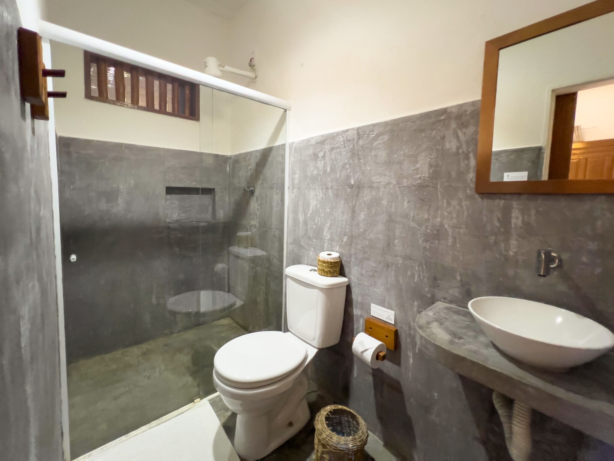 A bathroom with a toilet, a sink, and a shower area.
