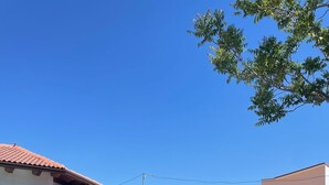 A house with a tiled roof, a hammock, and a patio area with outdoor furniture. - Rural house Las Gavias  (Matapozuelos)