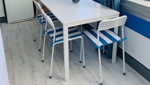 Una cocina compacta con un refrigerador blanco, armarios de madera y una cafetera.