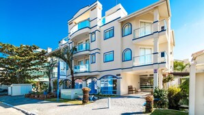 A multi-story hotel with balconies, a covered entrance, and a paved driveway. - Pousada Pedra Salgada (Bombinhas)