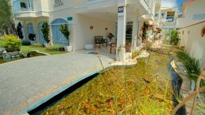 A hotel with a pool area, outdoor seating, and a clear view of the building's architecture. - Pousada Pedra Salgada (Bombinhas)