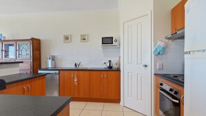A kitchen with wooden cabinets, a microwave, a stove, and a dishwasher.