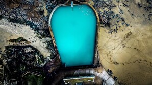 Vista aérea de una piscina rodeada de terreno rocoso.