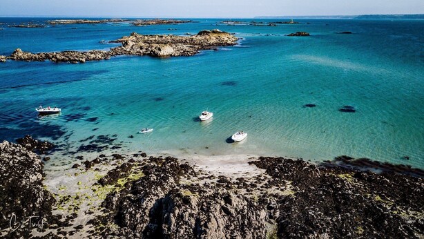 Un paisaje costero con costas rocosas y aguas turquesas cristalinas.