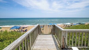 A wooden deck leading to a beach with umbrellas and chairs. - Duck Sea Sun | Oceanfront | Duck (Duck)