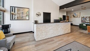 A modern living room with a stone reception desk, a large mirror, and a green sofa. - Dog Friendly Vail Lionshead Studio, LH Studio (Vail)
