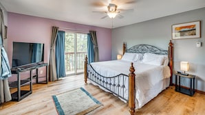 Ein Schlafzimmer mit einem Bett, einem Schreibtisch und einem Deckenventilator.