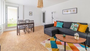 A modern living room with a sofa, coffee table, and dining set. - Appartement Mansana - Welkeys (Caluire-et-Cuire)