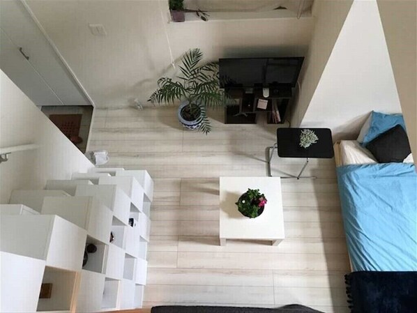 Cozy living space with a sofa, side table, and shelving unit, perfect for relaxing and unwinding.