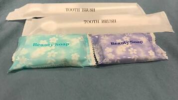 Two toothbrushes and two packets of beauty soap.