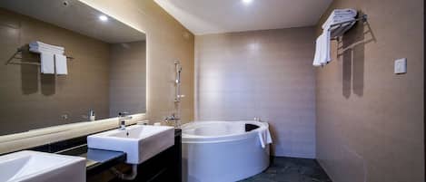 Un baño moderno con dos lavamanos, una bañera grande y un espejo.