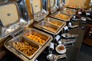 A buffet with various food items and utensils. - Bar Peepal Resort (Pokhara)