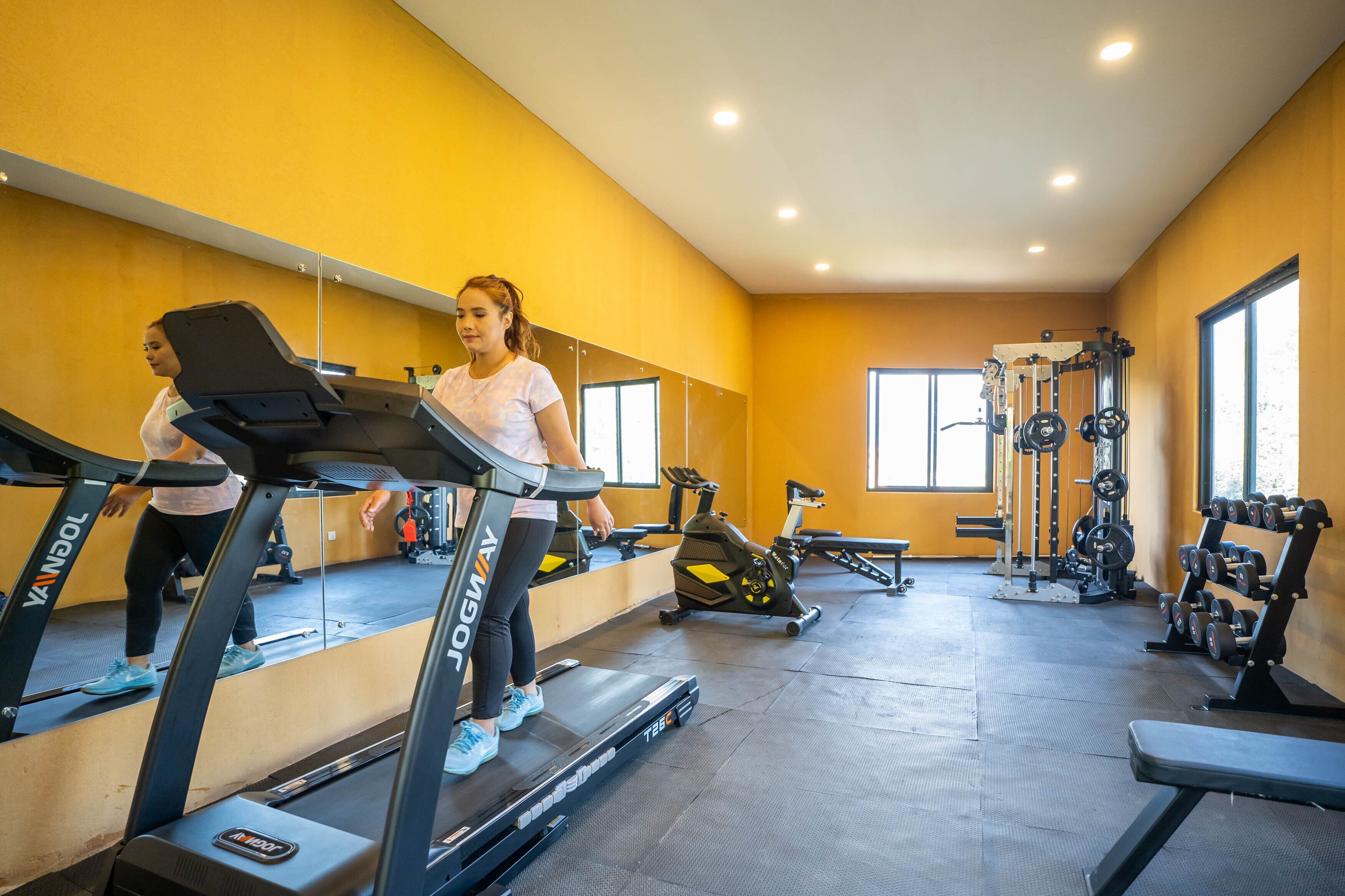 A gym with treadmills, exercise bikes, and weightlifting equipment.