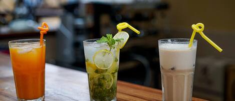 Tres vasos de bebidas sobre una mesa de madera.
