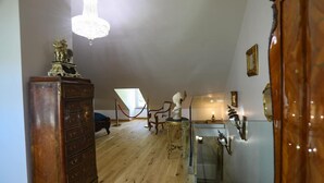 Una habitación con un aparador de madera, una araña de cristal, una vitrina de vidrio y un mueble de madera.