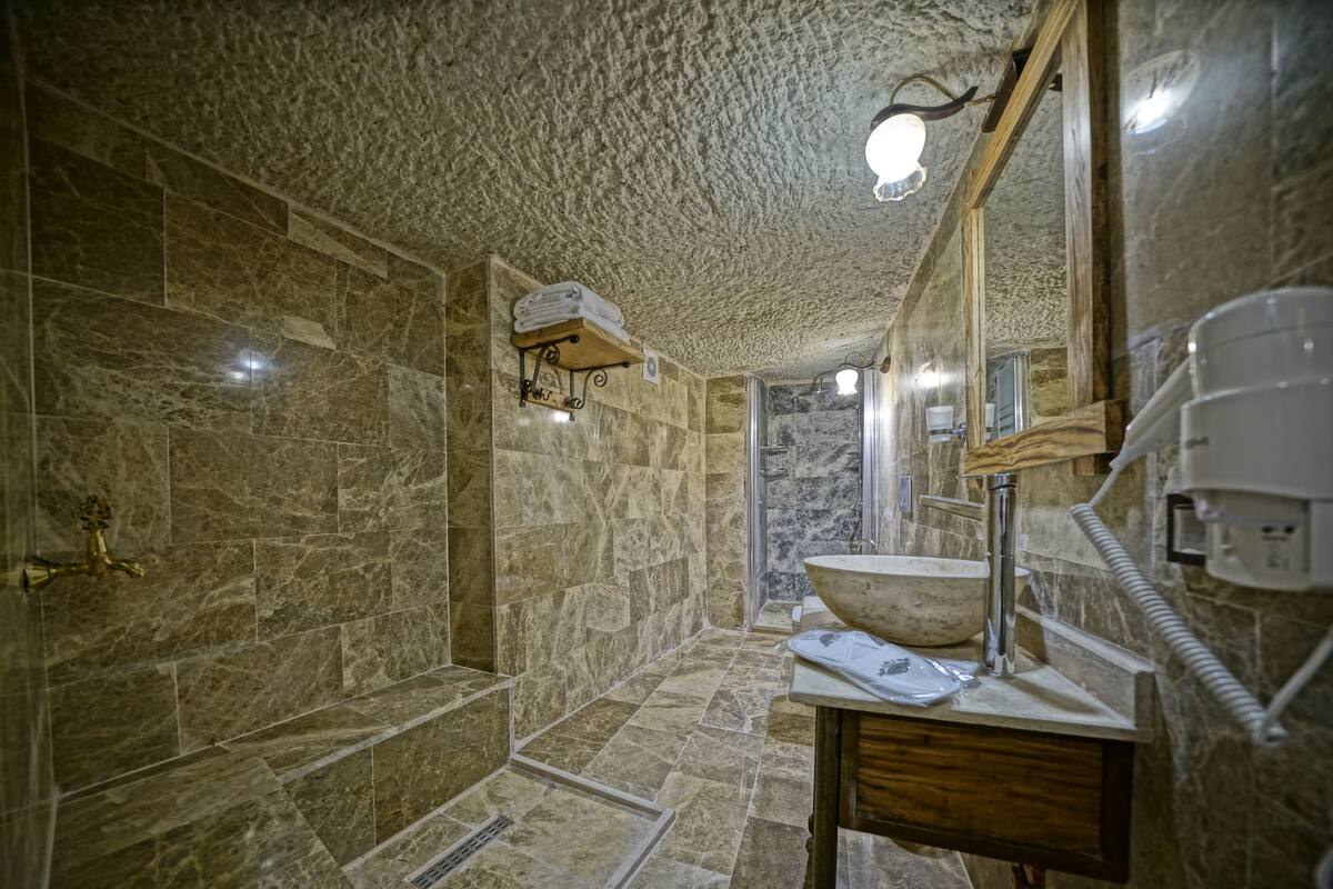 stone deluxe suite (ambar) | bathroom | eco-friendly toiletries, hair dryer, slippers, towels