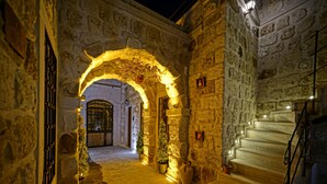 A stone-walled corridor with a staircase leading to an upper level. - Cappadocia Cave Lodge (Nevsehir)