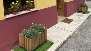 Un edificio amarillo con una sección inferior color borgoña, con el número 48 y una pequeña entrada con una puerta.