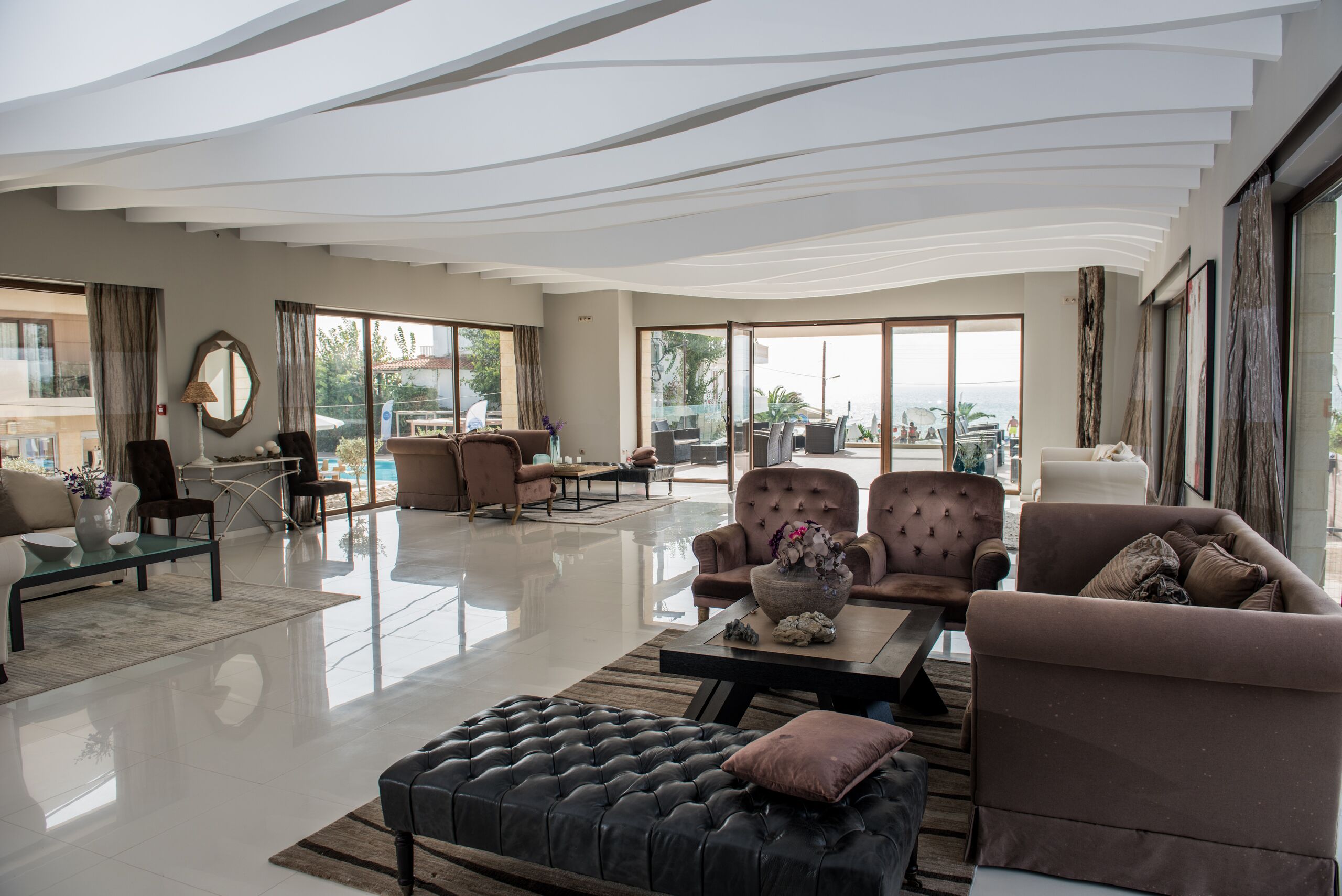 A spacious living area with a large window, a coffee table, and several sofas.