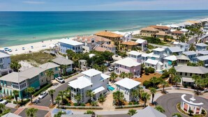 Una zona residencial costera con propiedades frente a la playa, una piscina y una plaza circular central.