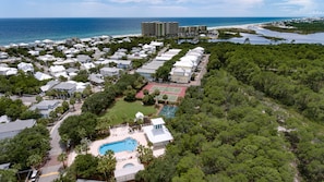 Área residencial com piscina, quadras de tênis e vista para o oceano.