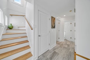 Un escalier avec des marches en bois menant à une porte blanche.