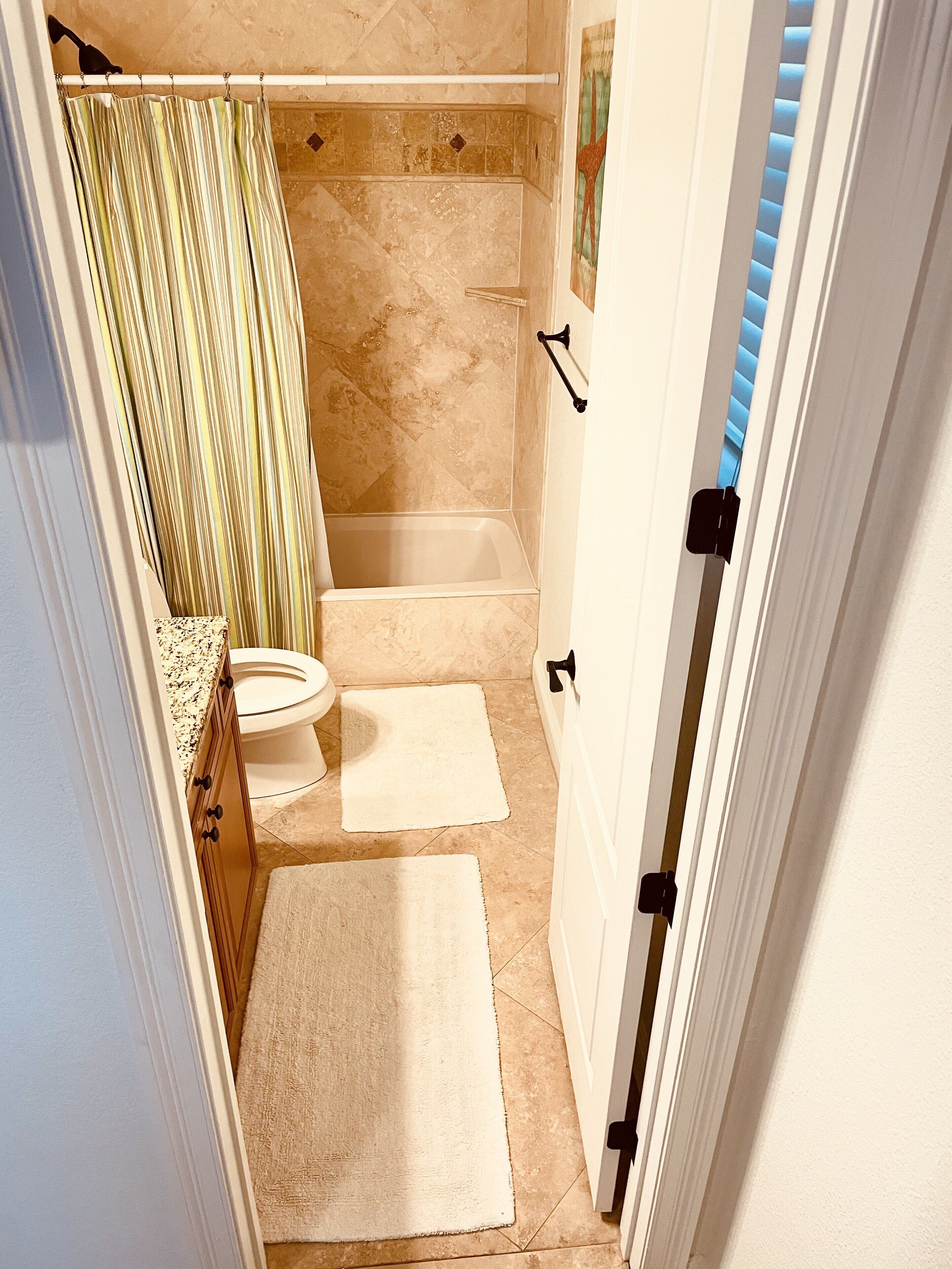A bathroom with a shower, toilet, and bathtub.