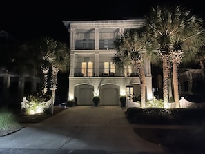 A multi-story building with a central entrance, large windows, and a well-lit facade. - Destin, Miramar Beach -  4,000 square ft. Steps to the Beach, plus private pool! (Miramar Beach)
